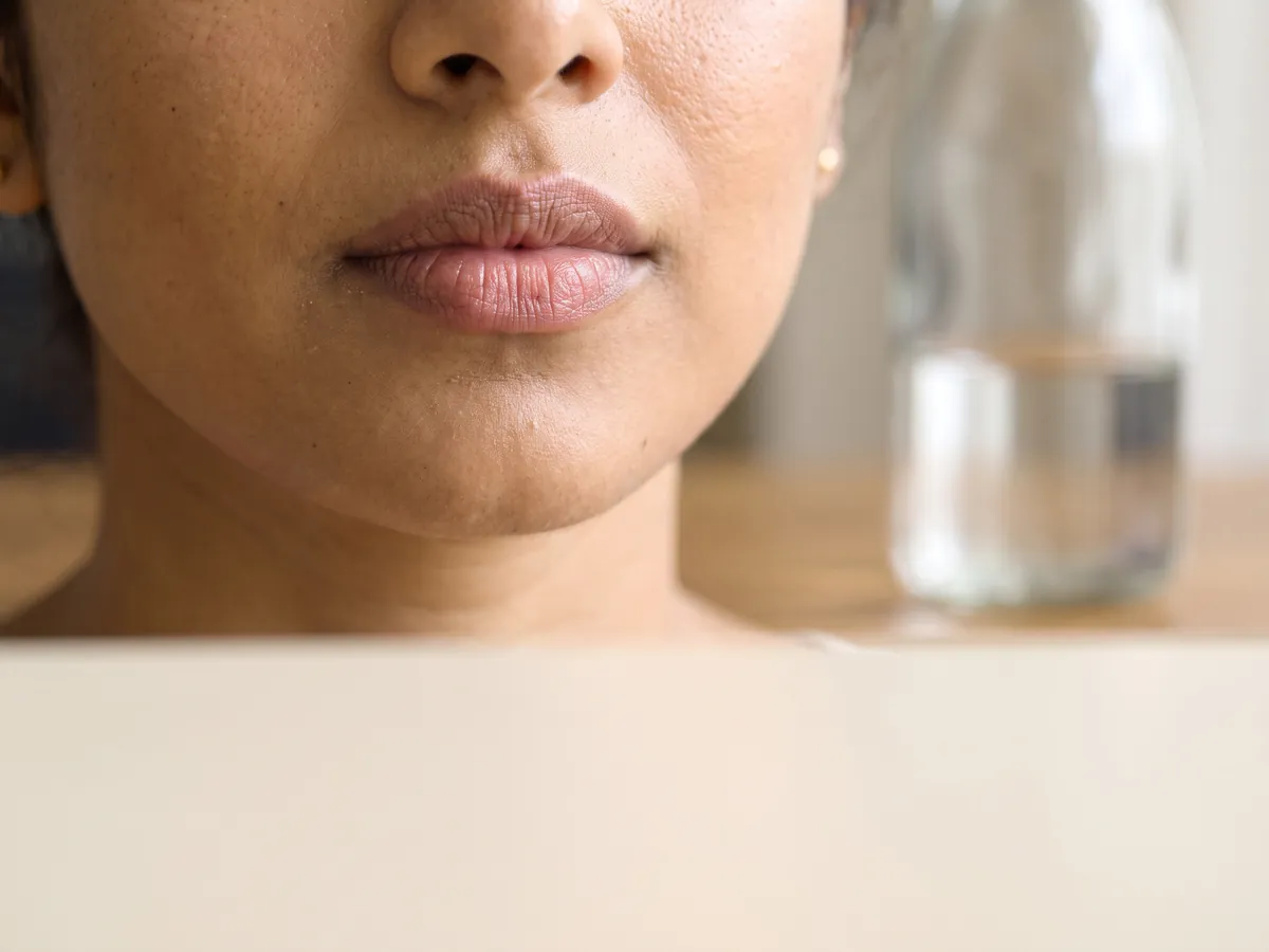 AI Customized Facial Jaipur: Dehydration: a half-empty water bottle on a desk, dry lips close-up | AI Aesthetics, C-Scheme