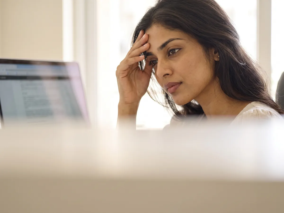 Fine Lines and Wrinkles Treatment Jaipur: Stress: the client at a laptop, hand on forehead, soft office light | AI Aesthetics, C-Scheme
