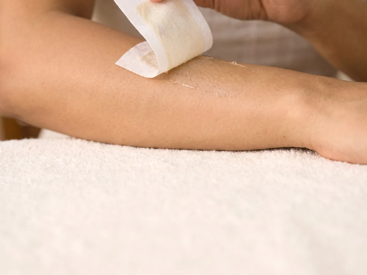 Bikini Laser Hair Removal Jaipur: Find bikini waxing painful, Waxing: a wax strip being peeled from a forearm | AI Aesthetics, C-Scheme